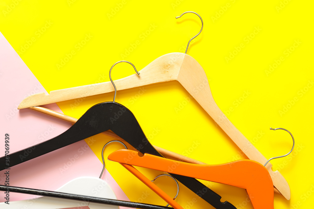 Clothes hangers on color background