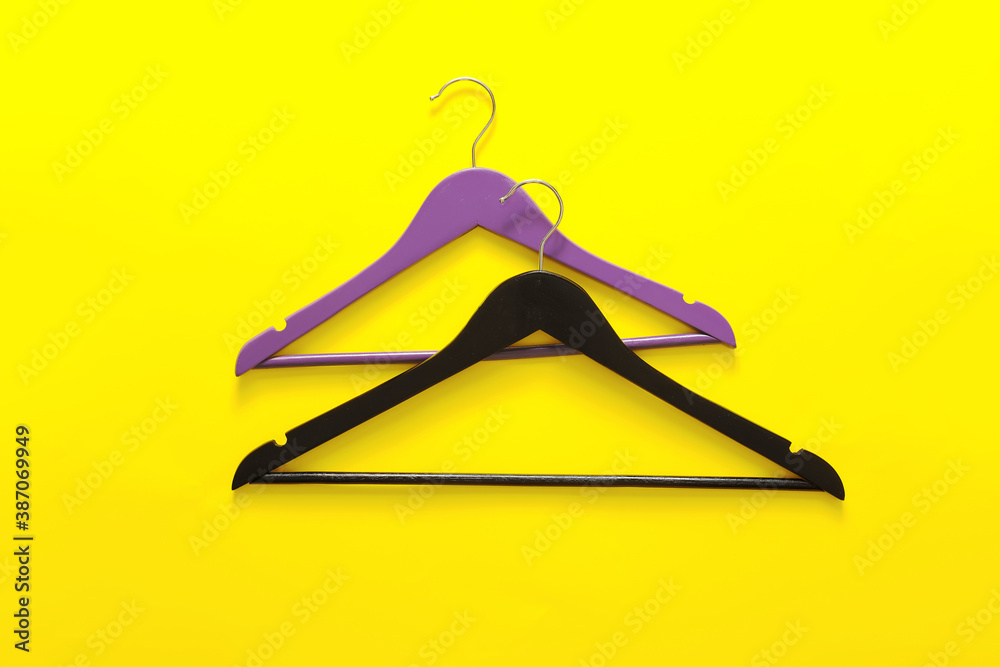 Clothes hangers on color background