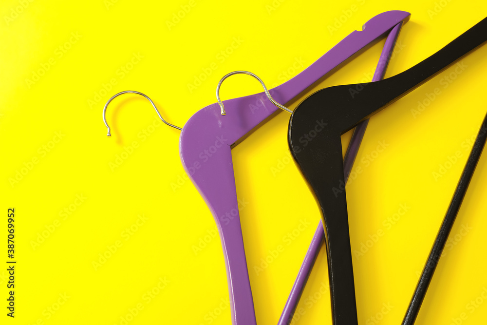 Clothes hangers on color background