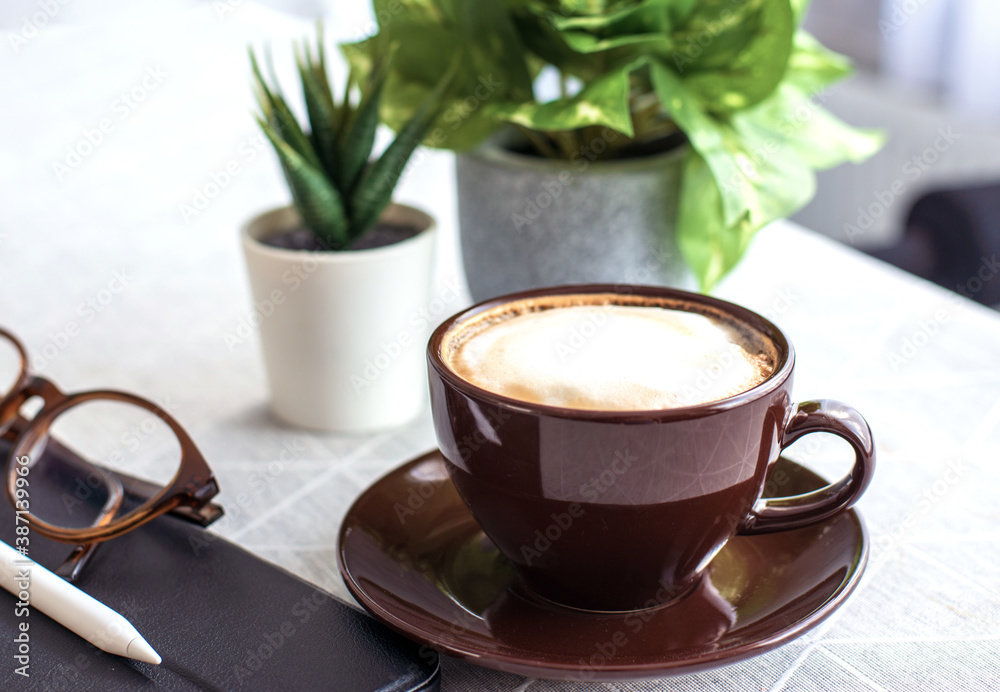 coffee break concept, close-up a cup of espresso coffee with a tablet, pencil, and the glasses on wh