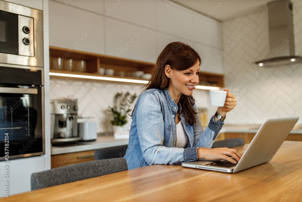 Sitting at home, kitchen in the background.