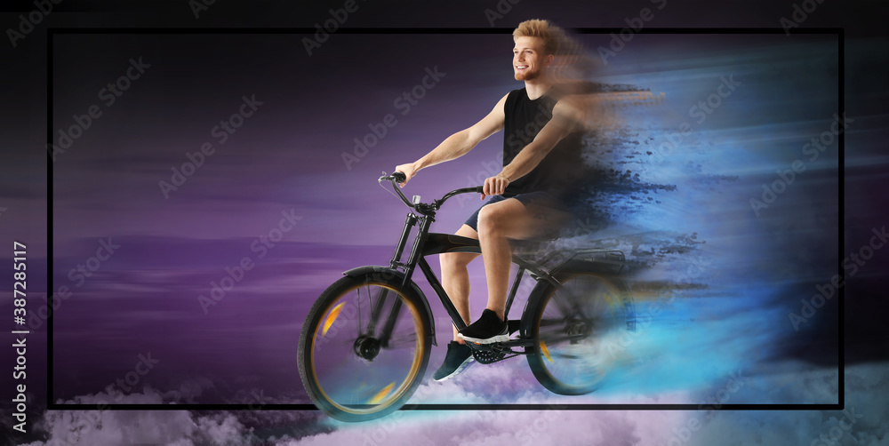 Sporty young man riding bicycle on dark color background