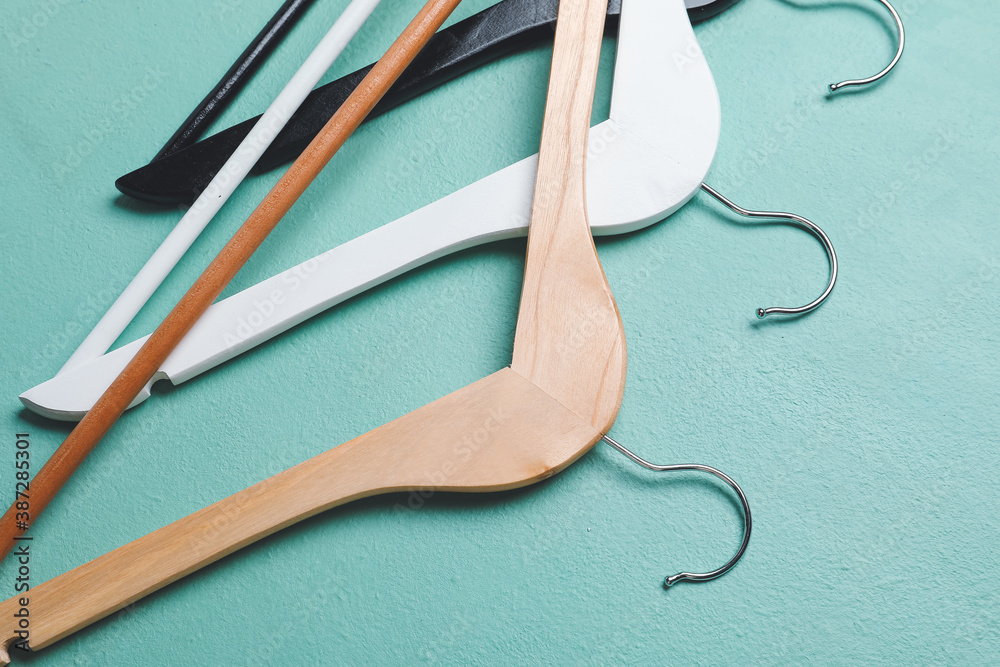 Clothes hangers on color background