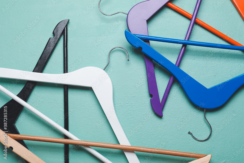 Clothes hangers on color background