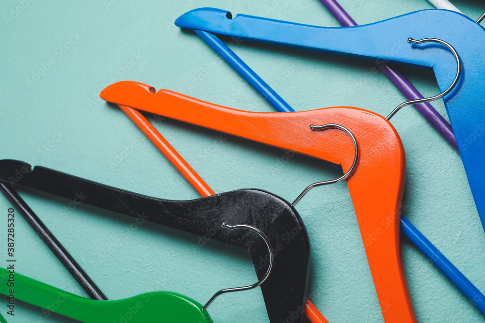 Clothes hangers on color background