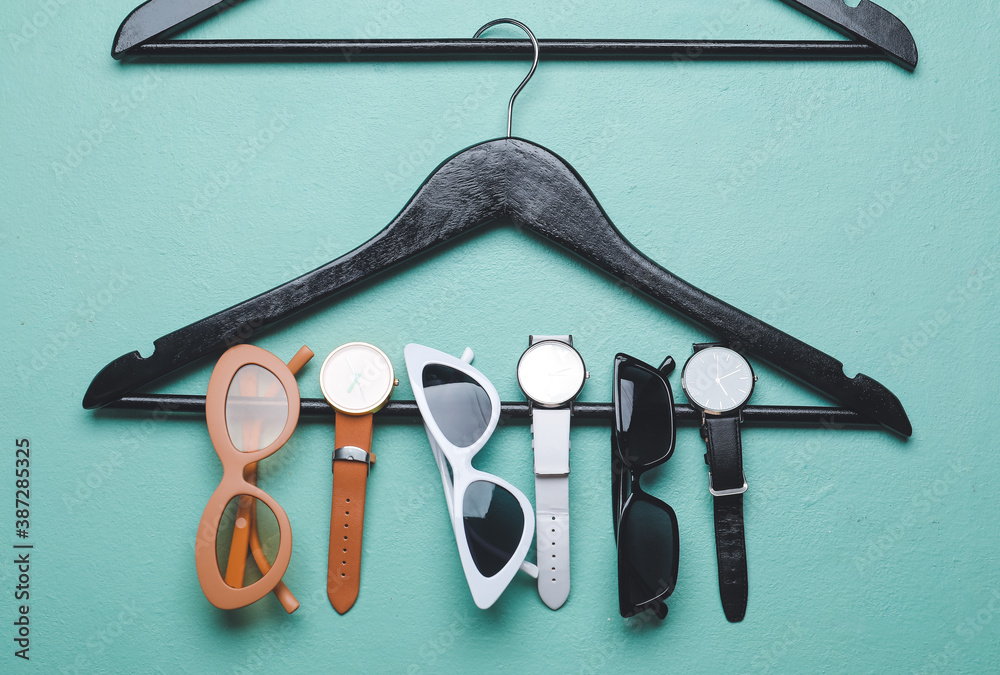 Clothes hangers and accessories on color background