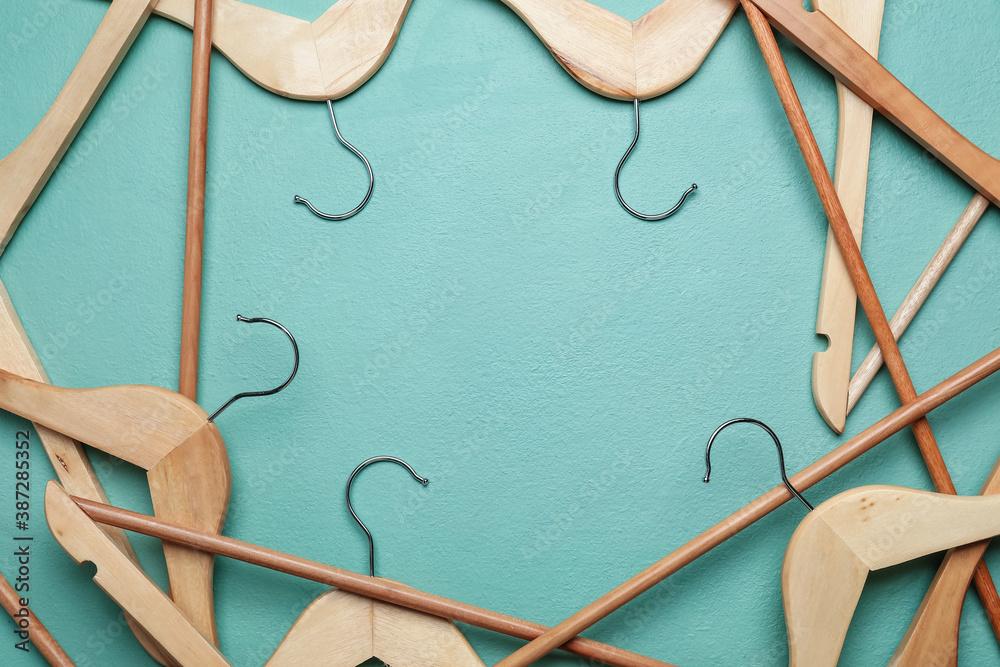 Clothes hangers on color background