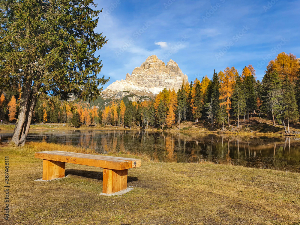 CLOSE UP: Empty wooden bench faces the breathtaking Lago dAntorno and Dolomites