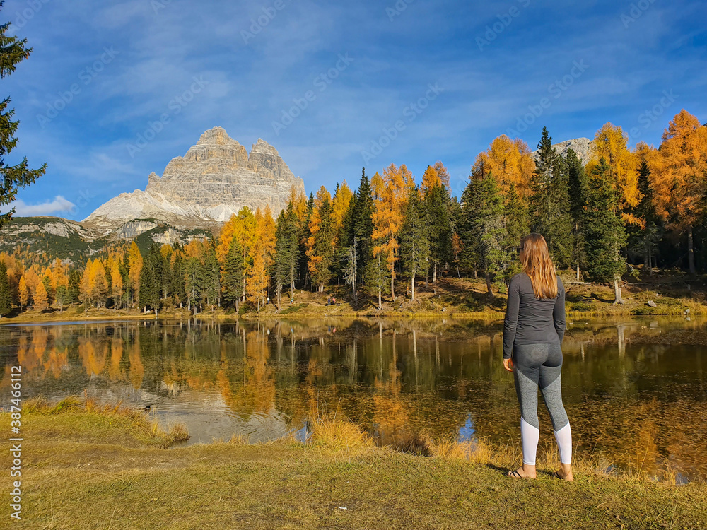 COPY SPACE: Woman poses in front of Lago dAntorno and fall colored landscape