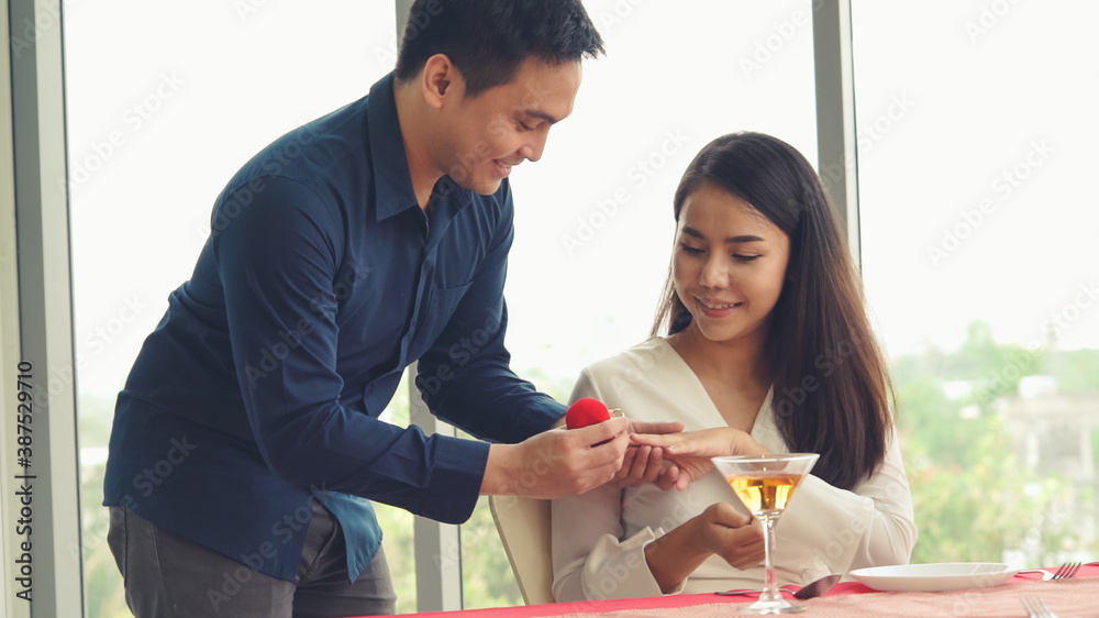 Romantic couple giving gift to lover at restaurant . Happy couple lifestyle .