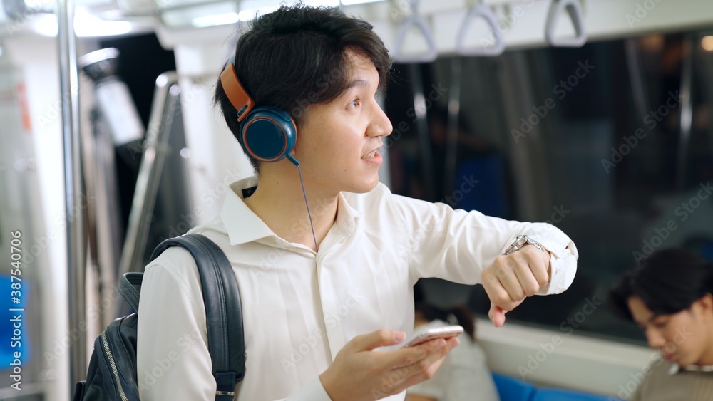 Businessman using mobile phone on public train . Urban city lifestyle commuting concept .