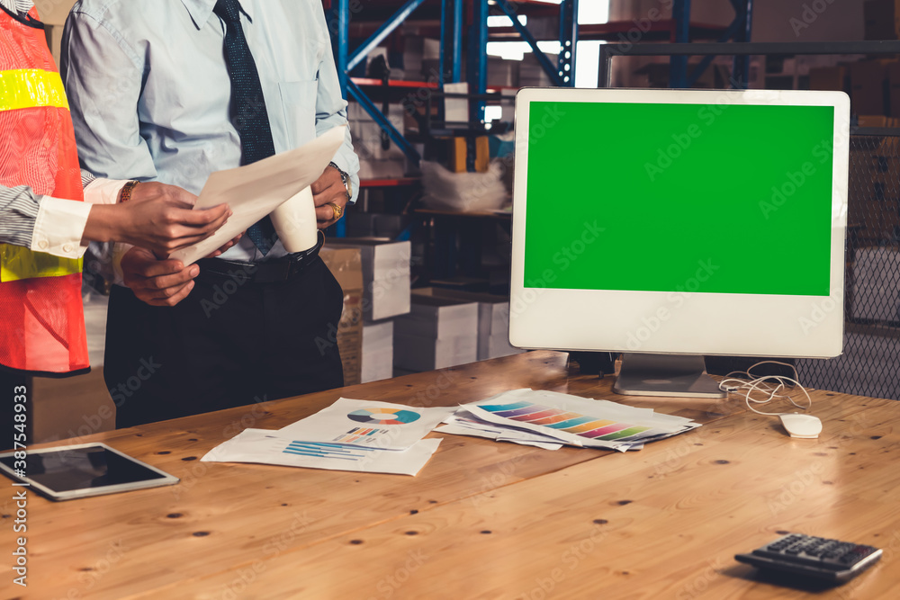 Computer with green screen display in warehouse storage room . Delivery and transportation software 