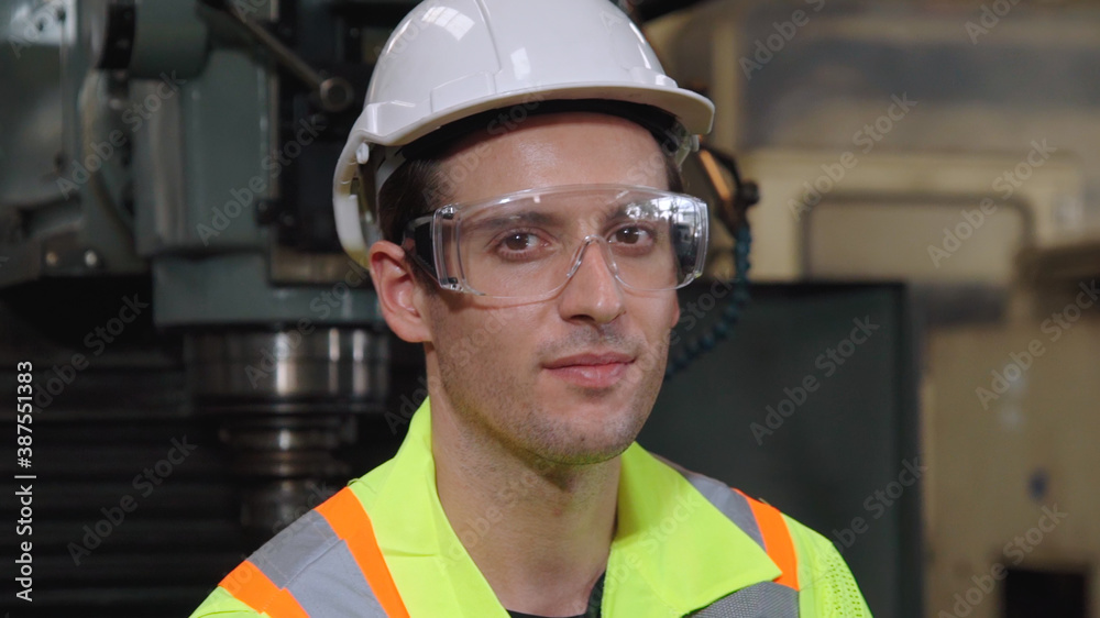 Young factory worker or engineer close up portrait in factory . Industry and engineering concept .