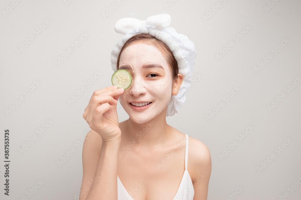 mask for skin woman, happy and funny girl makes a mask for face skin, holding sliced cucumber,