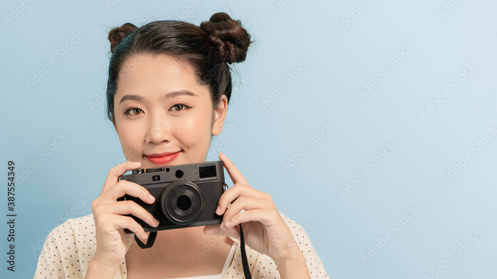 Woman traveler with a camera, blue background