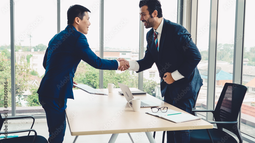 Job seeker and manager handshake in job interview meeting at corporate office. The young interviewee