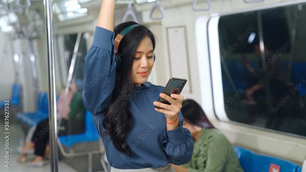 Young woman mobile phone on public train . Urban city lifestyle commuting concept .