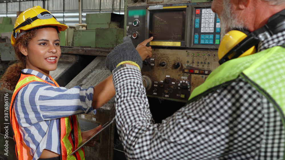 Group of factory workers using machine equipment in factory workshop . Industry and engineering conc