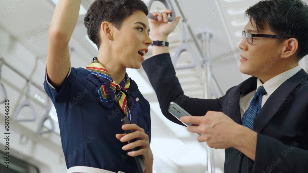 Businessman and woman talking on public train . Urban city lifestyle commuting concept .