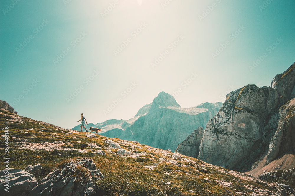 Woman hiking with her dog in mounatin in Julian Alps -  Trekking Discovery Travel Destination Concep