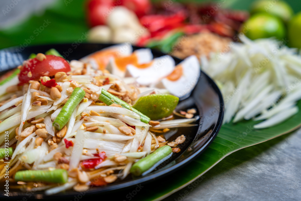 Som Tam Thai and Ingredients Papaya Salad with Salted Egg Thai Food Style on Banana Leaf background.