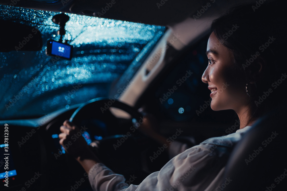  Asian woman is driving alone at night. Its raining. She is lonely.