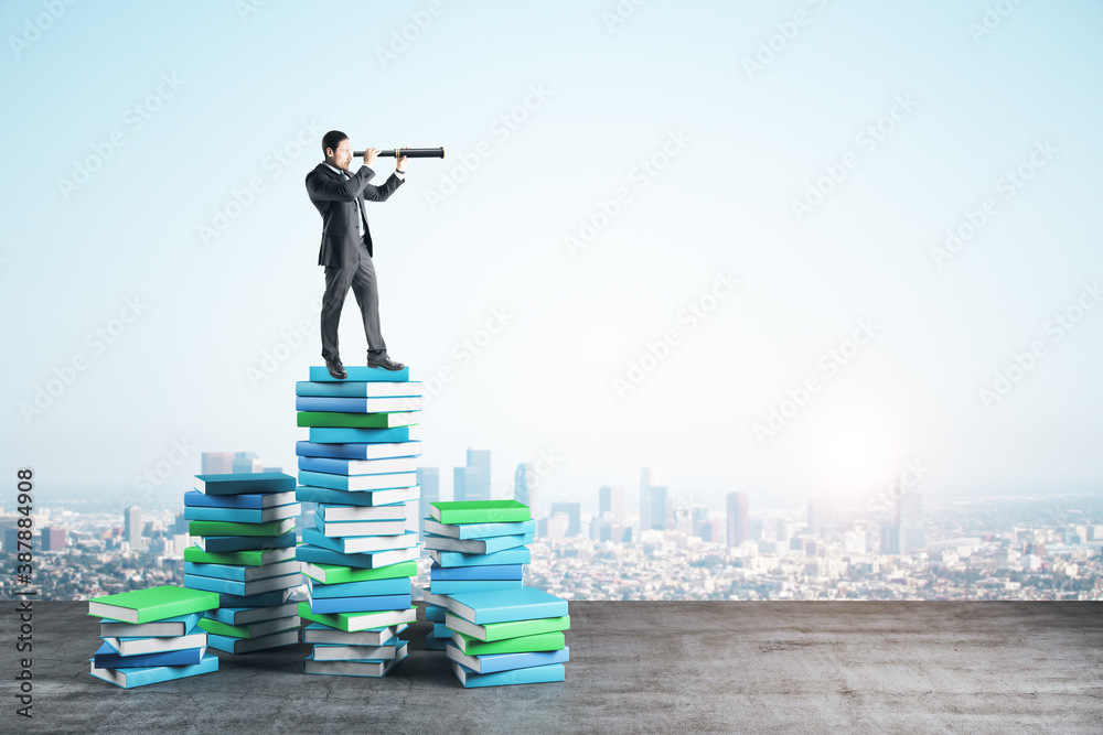 Businessman with telescope on color books