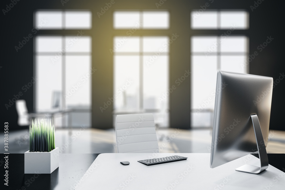 Modern office interior with city view and computer on table.