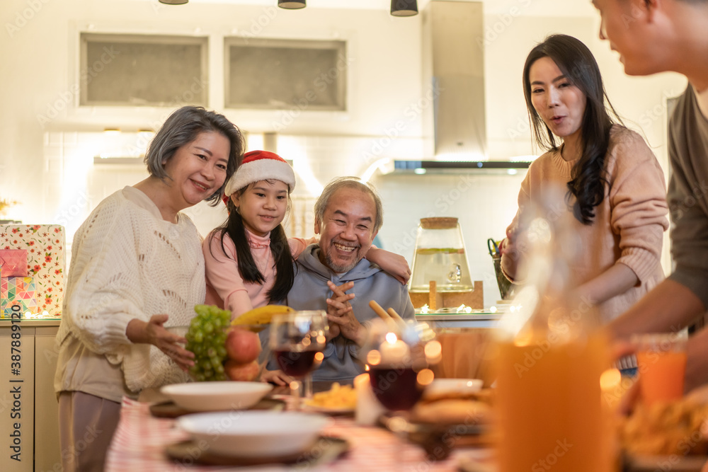 Asian big family preparing foods and drinks to serve on dining table.