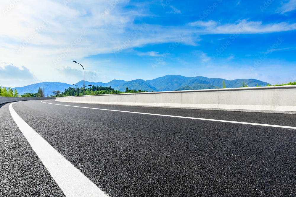 Asphalt road and green mountain natural scenery in Hangzhou on a sunny day.