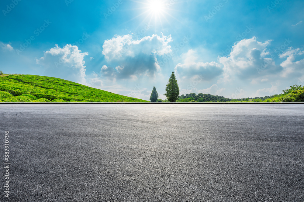 Race track road and green tea plantations with mountain natural scenery in Hangzhou on a sunny day.