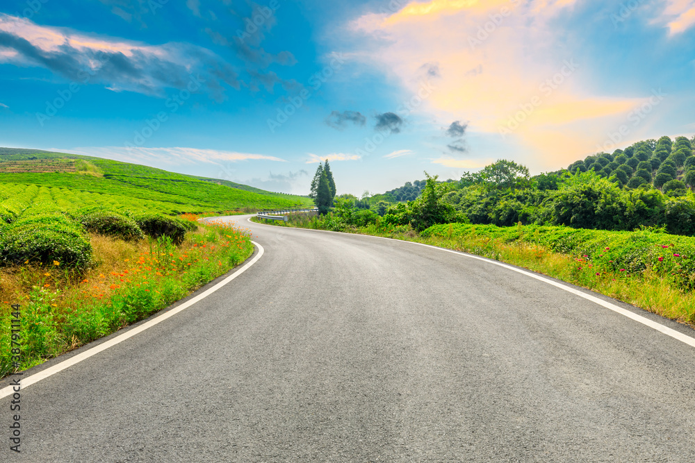 Countryside asphalt road and green tea plantations with mountain natural scenery in Hangzhou at sunr