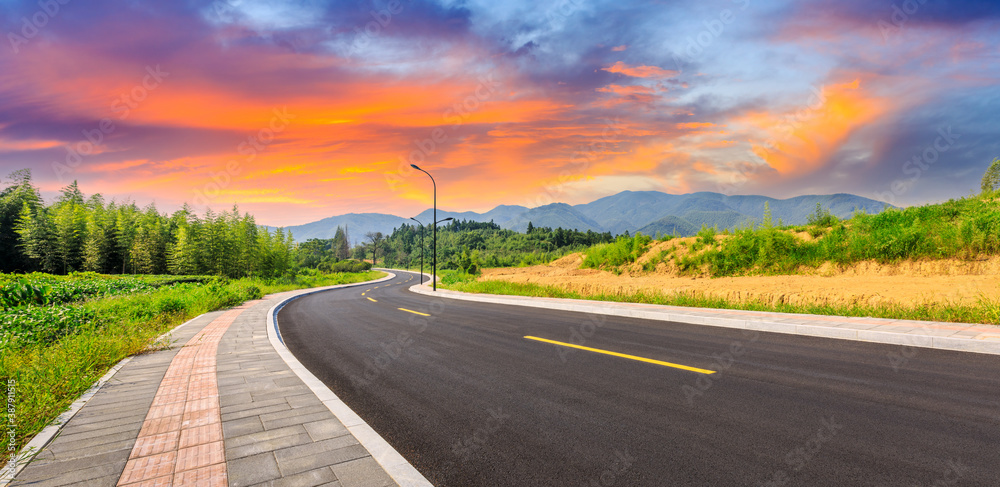 Countryside asphalt road and green plants with mountain natural scenery in Hangzhou on a sunny day.