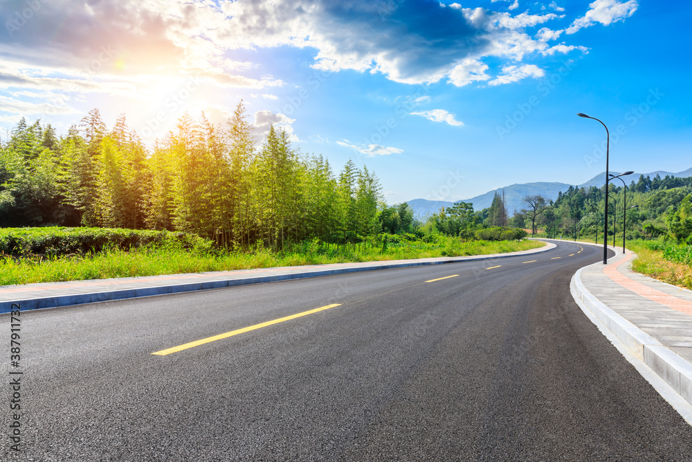 Countryside asphalt road and green plants with mountain natural scenery in Hangzhou on a sunny day.