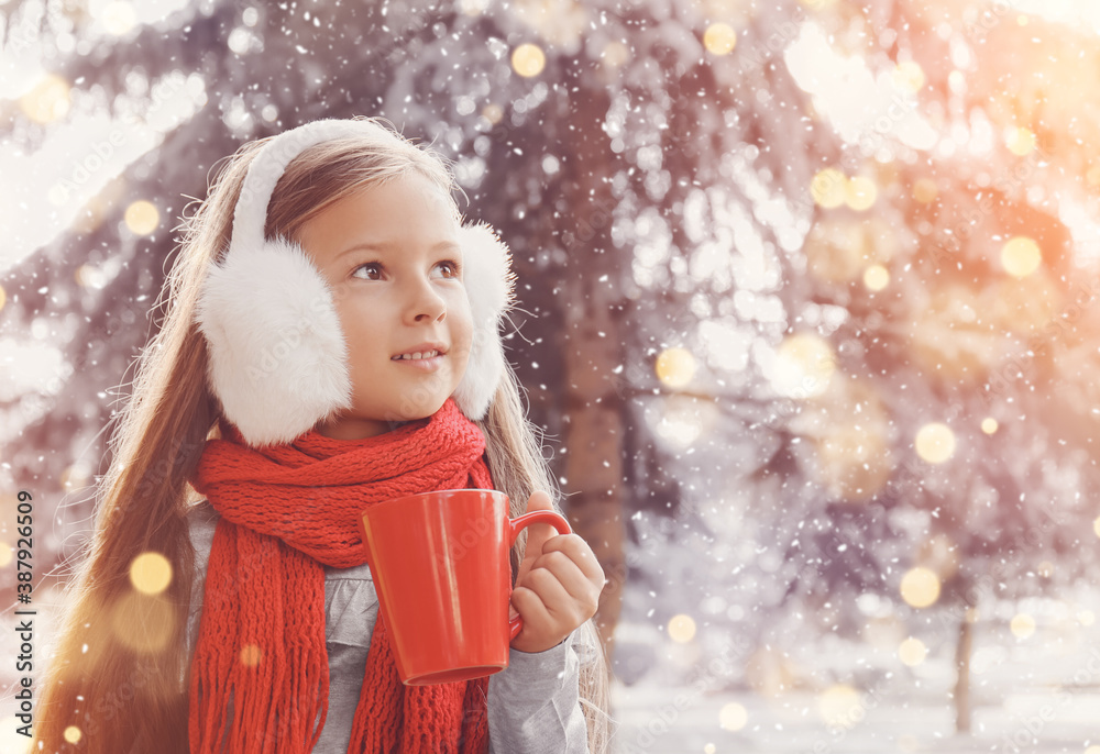 Cute little girl with cup of hot chocolate outdoors on winter day