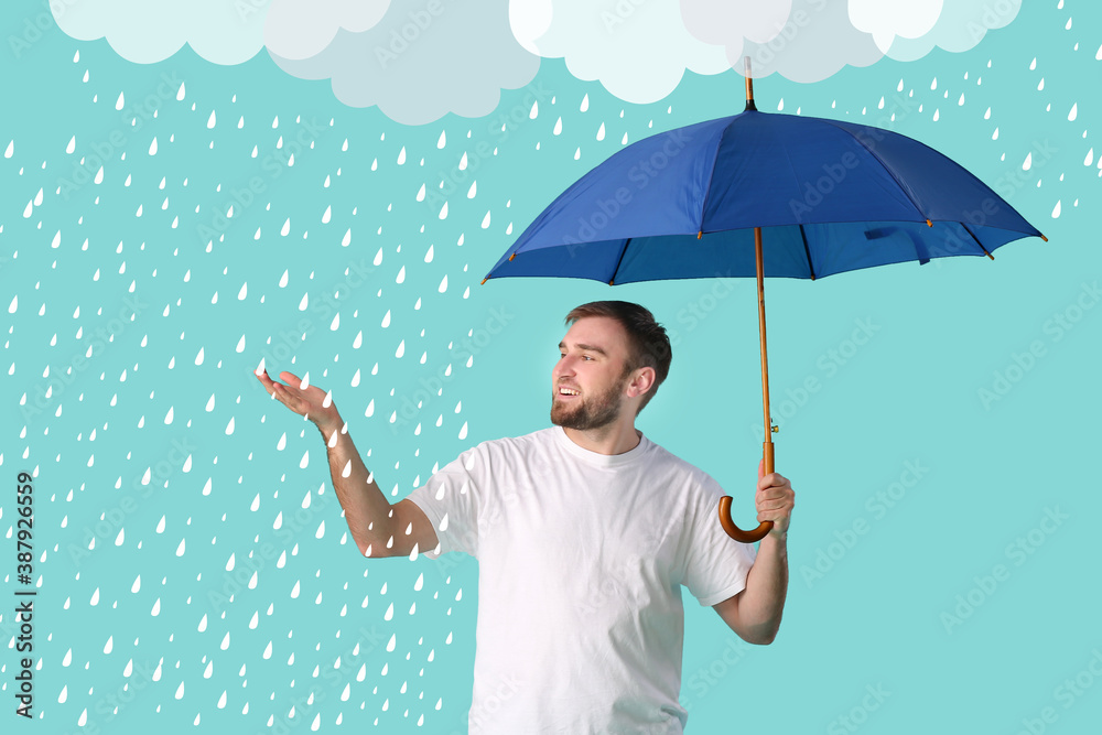 Handsome young man holding umbrella on background with drawn rain