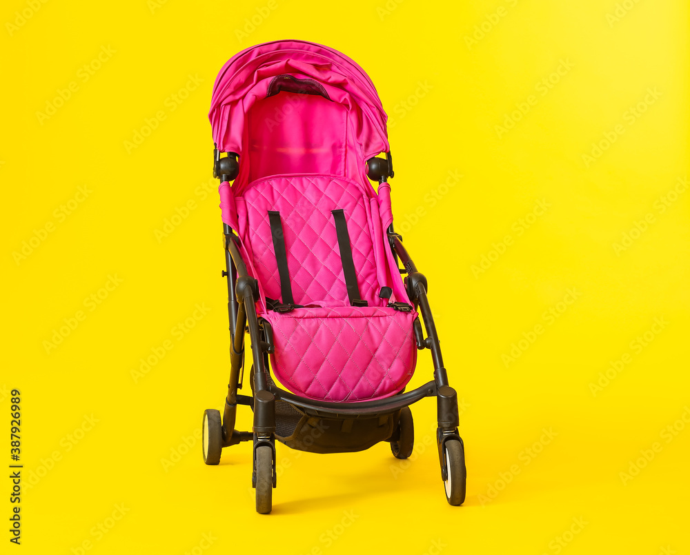 Modern baby stroller on color background