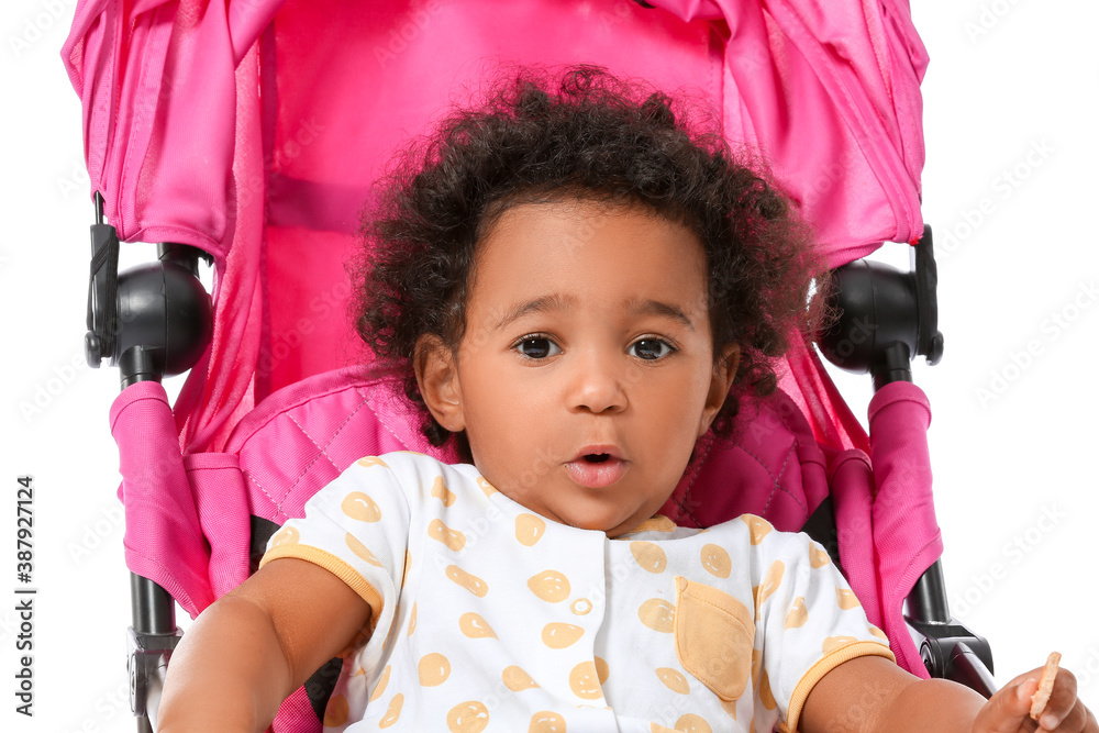 Cute African-American baby in stroller on white background