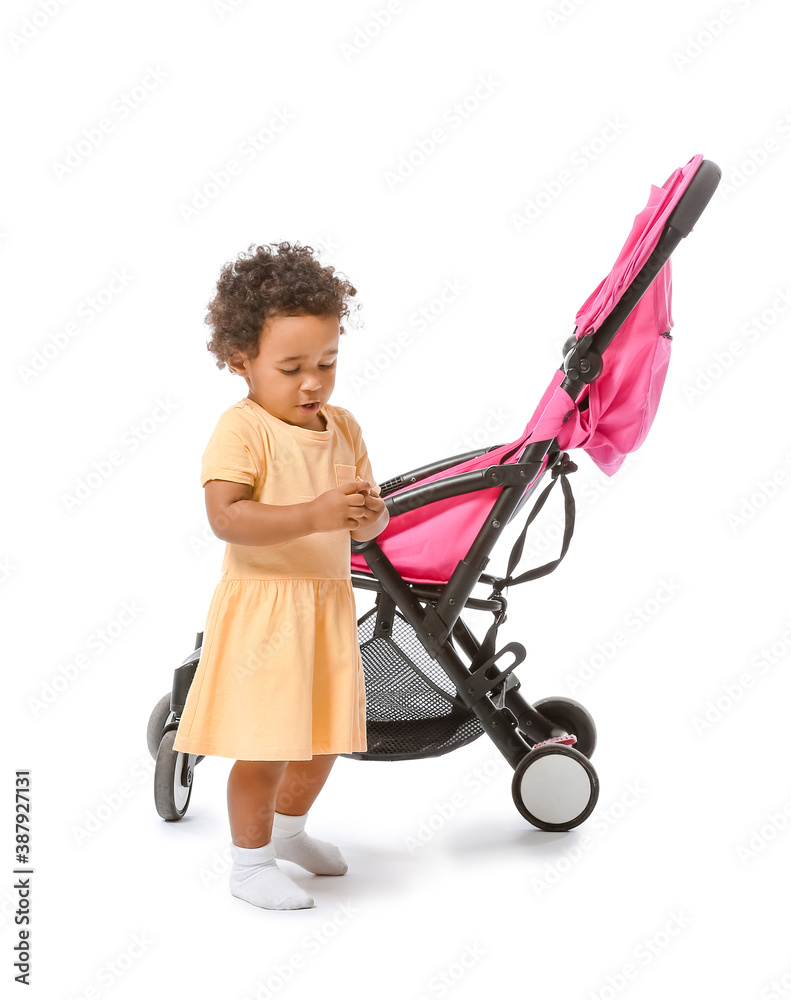 Cute African-American baby and stroller on white background