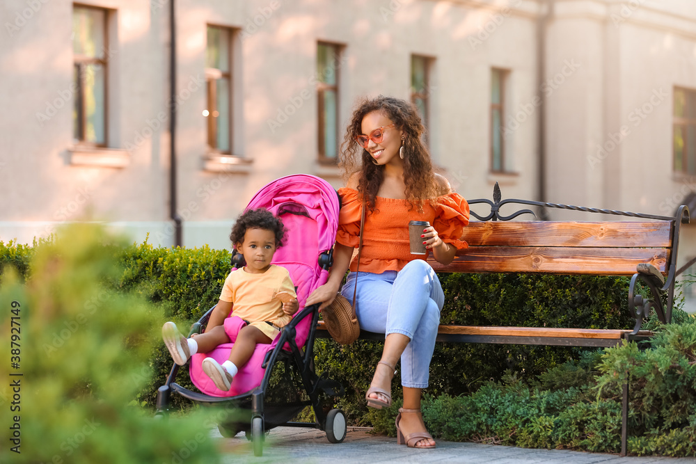 African-American woman and her cute baby in stroller outdoors