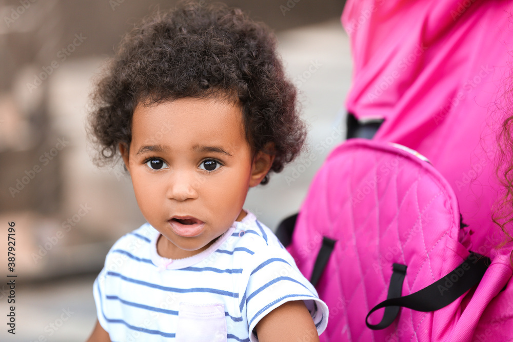 Cute African-American baby in stroller outdoors