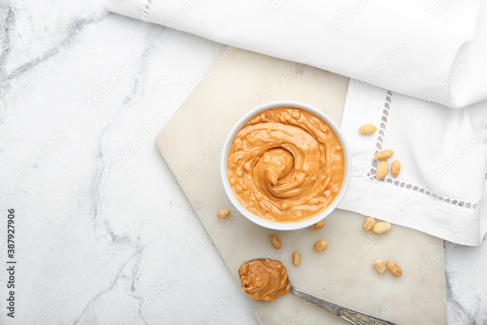 Bowl with tasty peanut butter on table