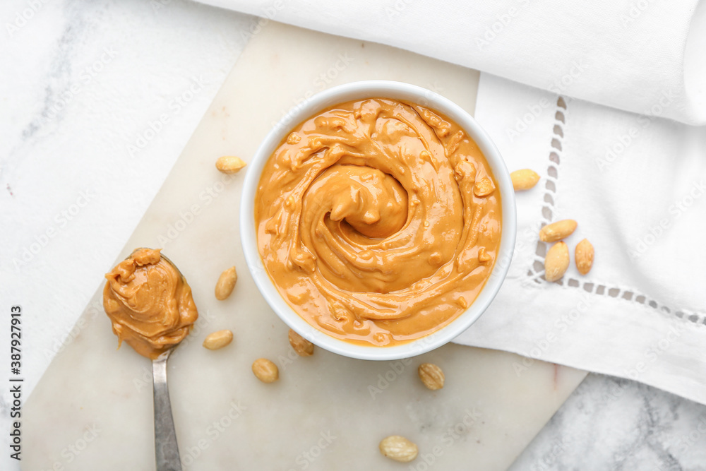 Bowl with tasty peanut butter on table