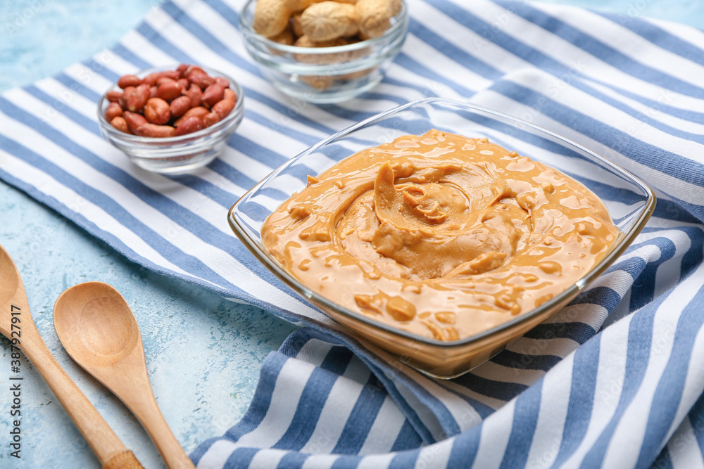 Bowl with tasty peanut butter on table