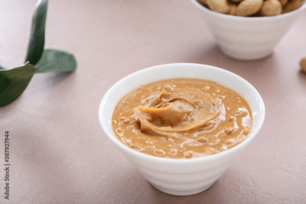 Bowl with tasty peanut butter on table