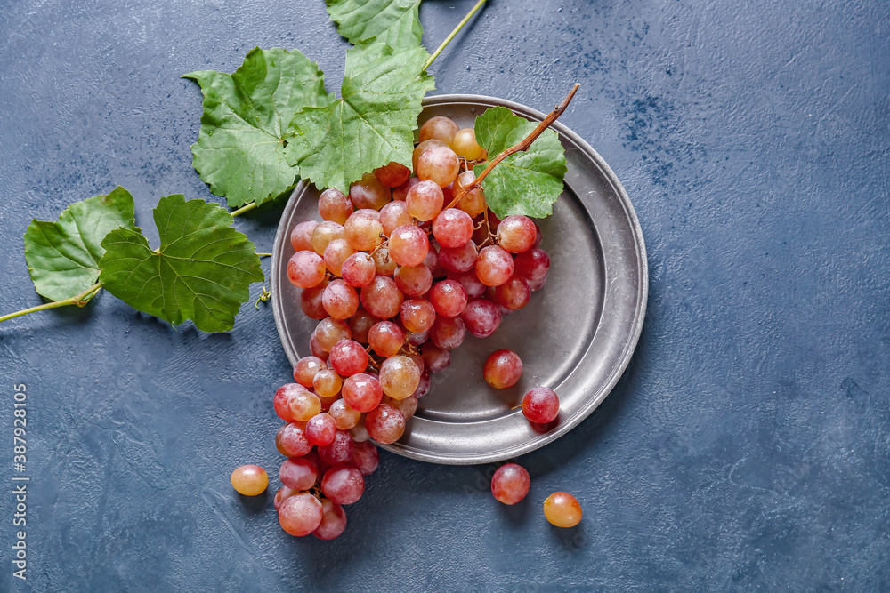 Plate with sweet ripe grapes on table