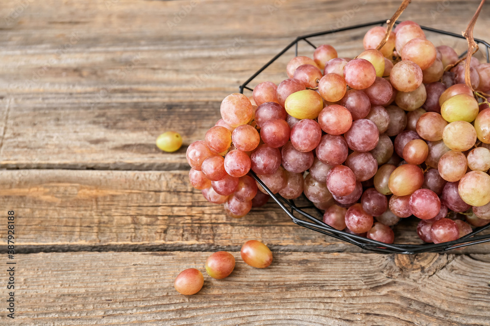 Bowl with sweet ripe grapes on wooden table