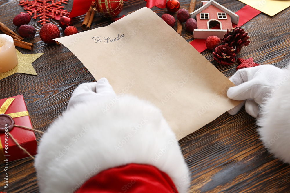 Santa with letter and Christmas decor on wooden background