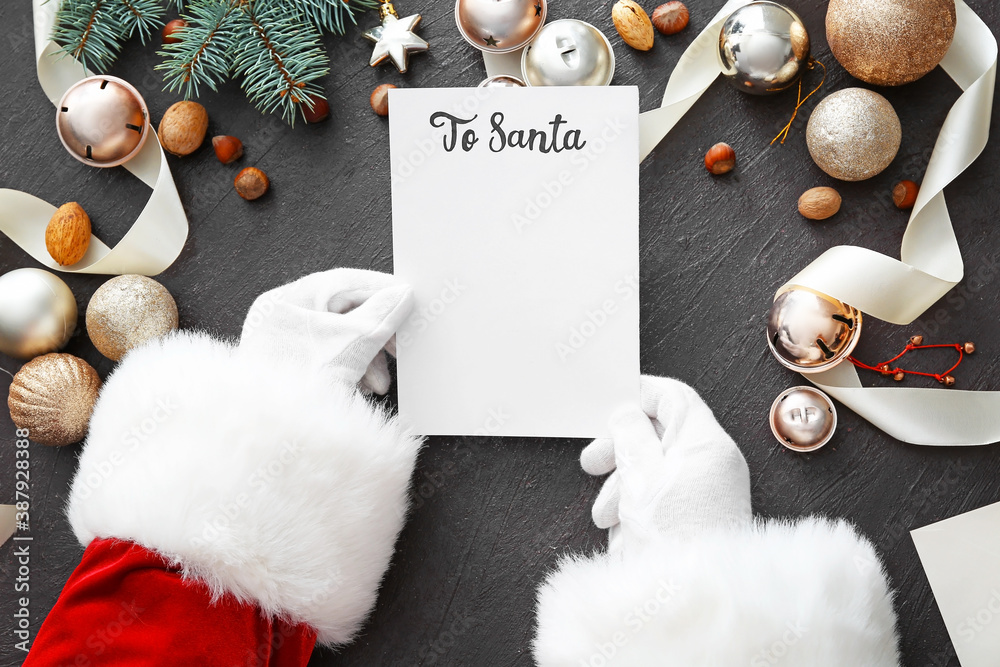 Santa with letter and Christmas decor on dark background