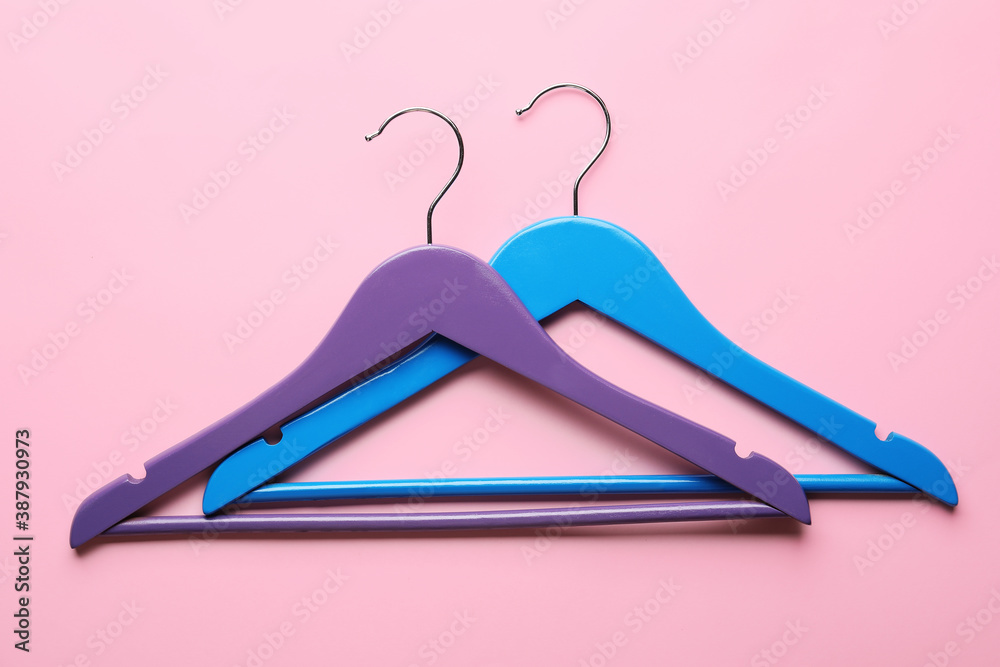 Clothes hangers on color background